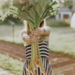 girl holding large bunch of rhubarb