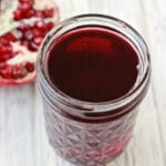 pomegranate next to a pomegranate jelly jar