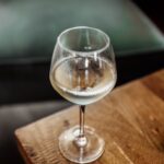 glass of white wine on a wooden coffee table