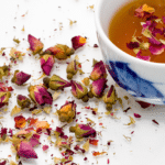 scattered rose petals and a cup of rose petal tea