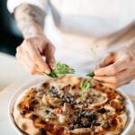 chef adding herbs to a fig pizza