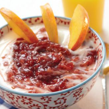 decorated bowl with yogurt, jam and sliced peaches