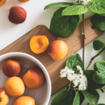 fresh apricots in a white bowl and on a cutting board