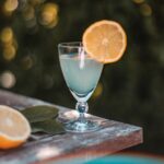 outdoor table with a glass of margarita and a side of citrus