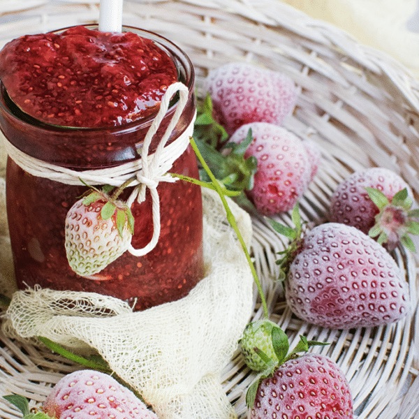 frozen strawberries next to a jar of freezer jam