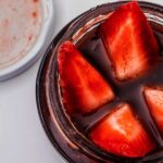 quartered strawberries in a jar of red fruit juice