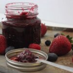 jar of triple berry jam surrounded by fresh berries