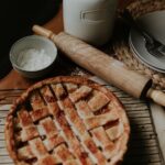 fresh apple pie surrounded by ingredients