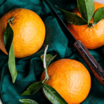 Fresh oranges on green fabric